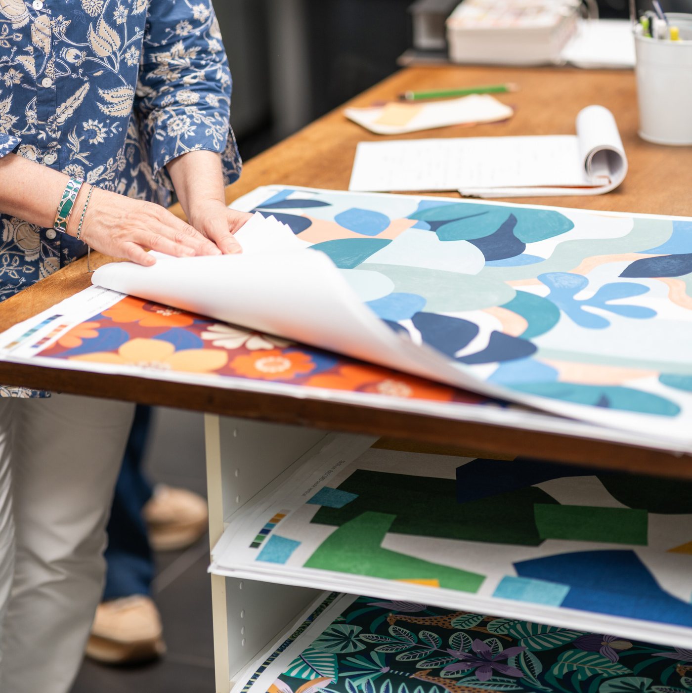 Planches de motifs étalées sur la table de l’atelier